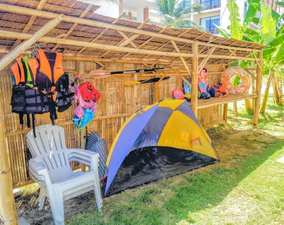 Bamboo beach hut stocked with life jackets, paddles, snorkel gear, a beach tent and floats